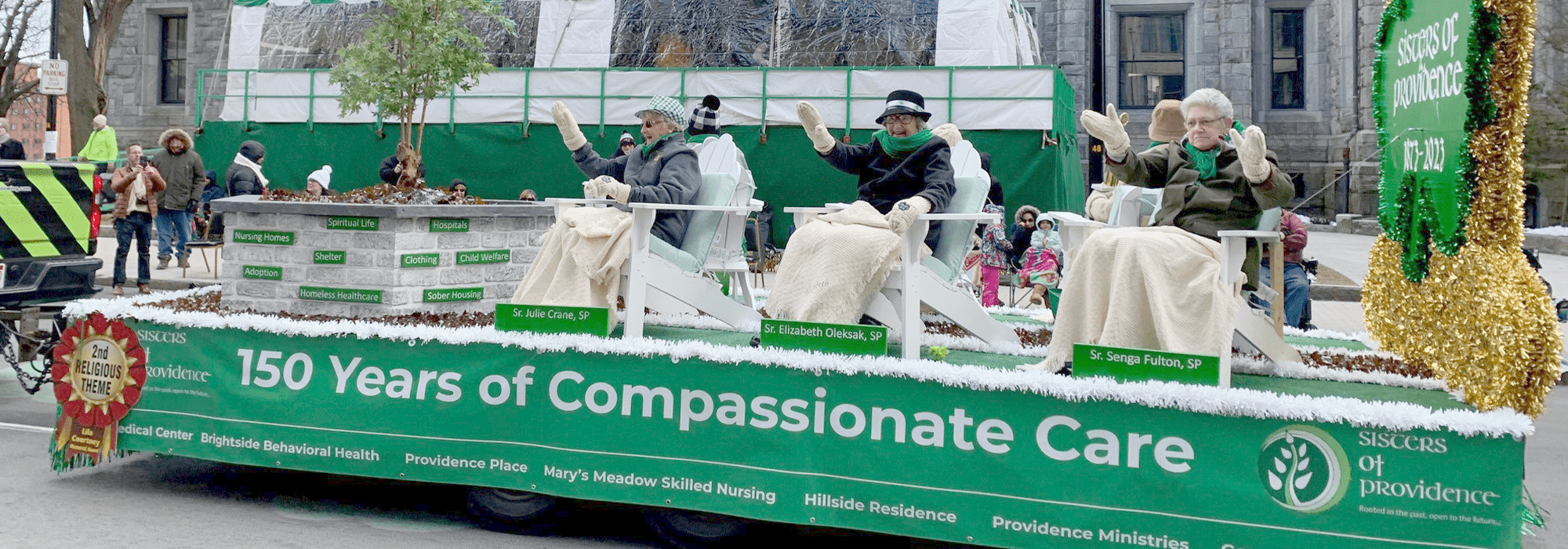 photo of sisters of providence waving from their 150th anniversary float at the 2023 holyoke saint patrick's day parade.